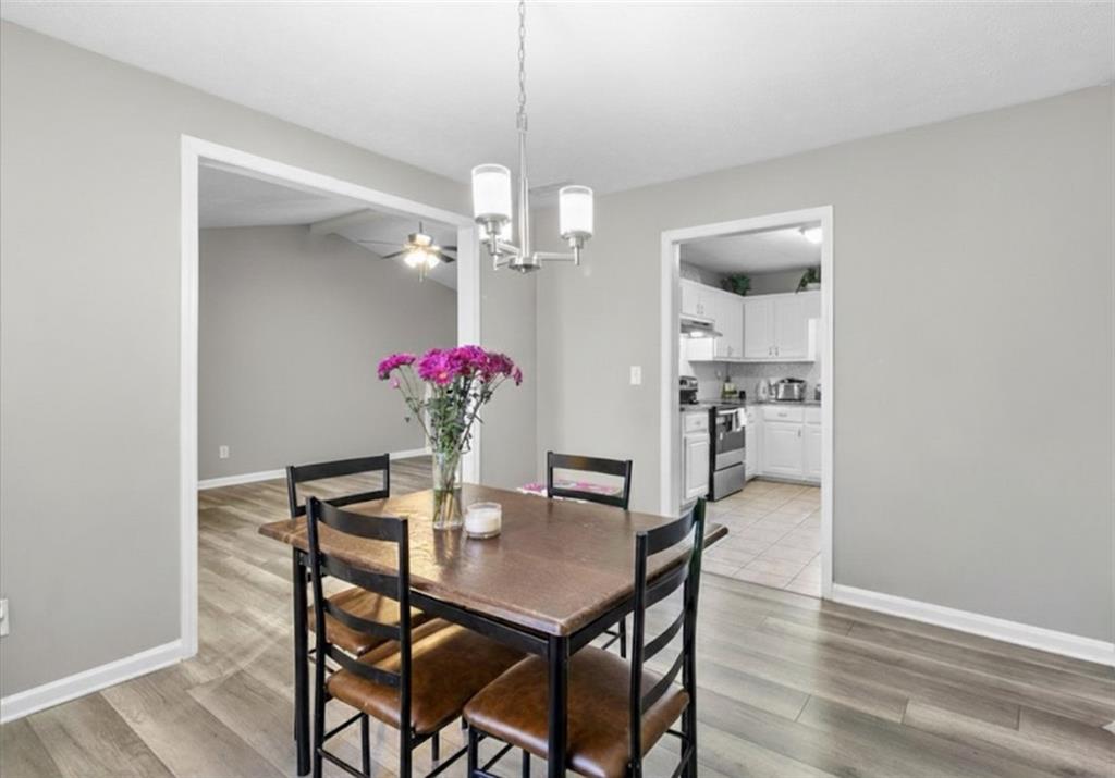 472 Oak Hill Road Covington, GA 30016 - Photo 11 of 41 a dining room with furniture a chandelier and wooden floor