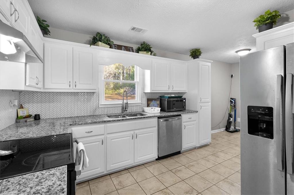 472 Oak Hill Road Covington, GA 30016 - Photo 14 of 41 a kitchen with stainless steel appliances granite countertop a refrigerator sink and stove