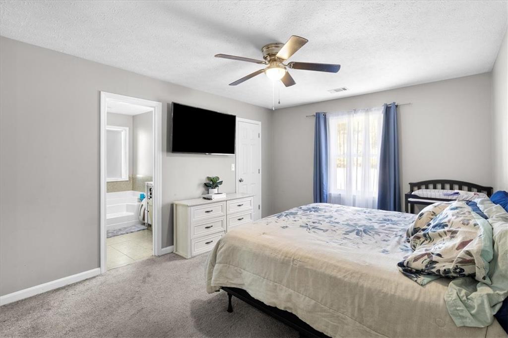 472 Oak Hill Road Covington, GA 30016 - Photo 18 of 41 a bedroom with a bed and a flat screen tv