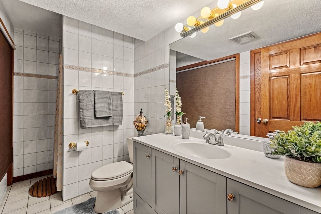 3 Macone Circle Stoneham, MA 02180 - Photo 23 of 26 a bathroom with a sink a toilet and shower