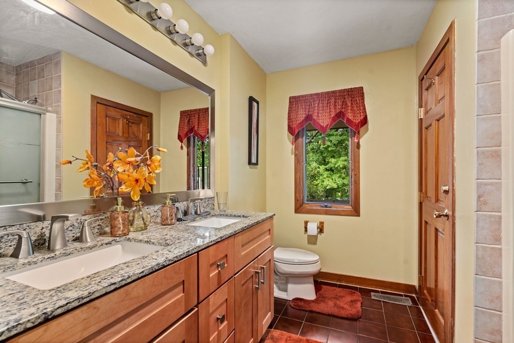 3 Macone Circle Stoneham, MA 02180 - Photo 24 of 26 a bathroom with a granite countertop sink a large mirror a bathtub and a shower