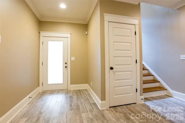 an empty room with wooden floor and entryway