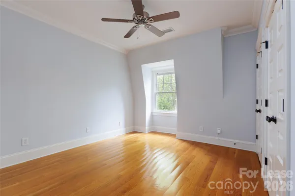 an empty room with a window and ceiling fan