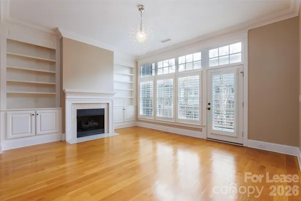 a view of empty room with wooden floor and fireplace