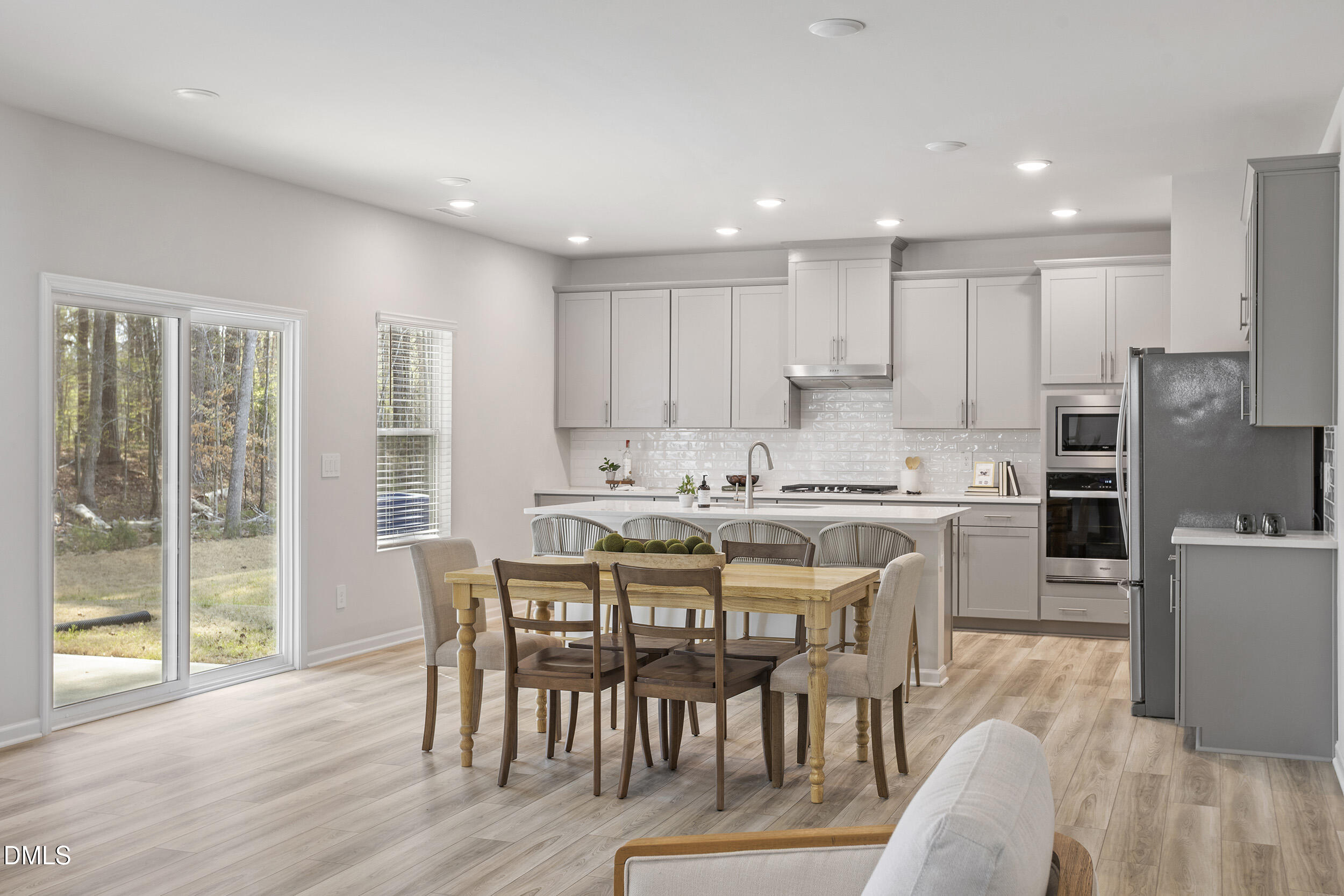 1105 Umstead Grv Way Durham, NC 27712 - Photo 15 of 38 a kitchen with stainless steel appliances granite countertop a dining table chairs refrigerator and sink