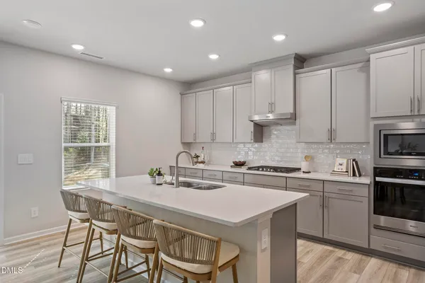a kitchen with a dining table chairs sink and cabinets