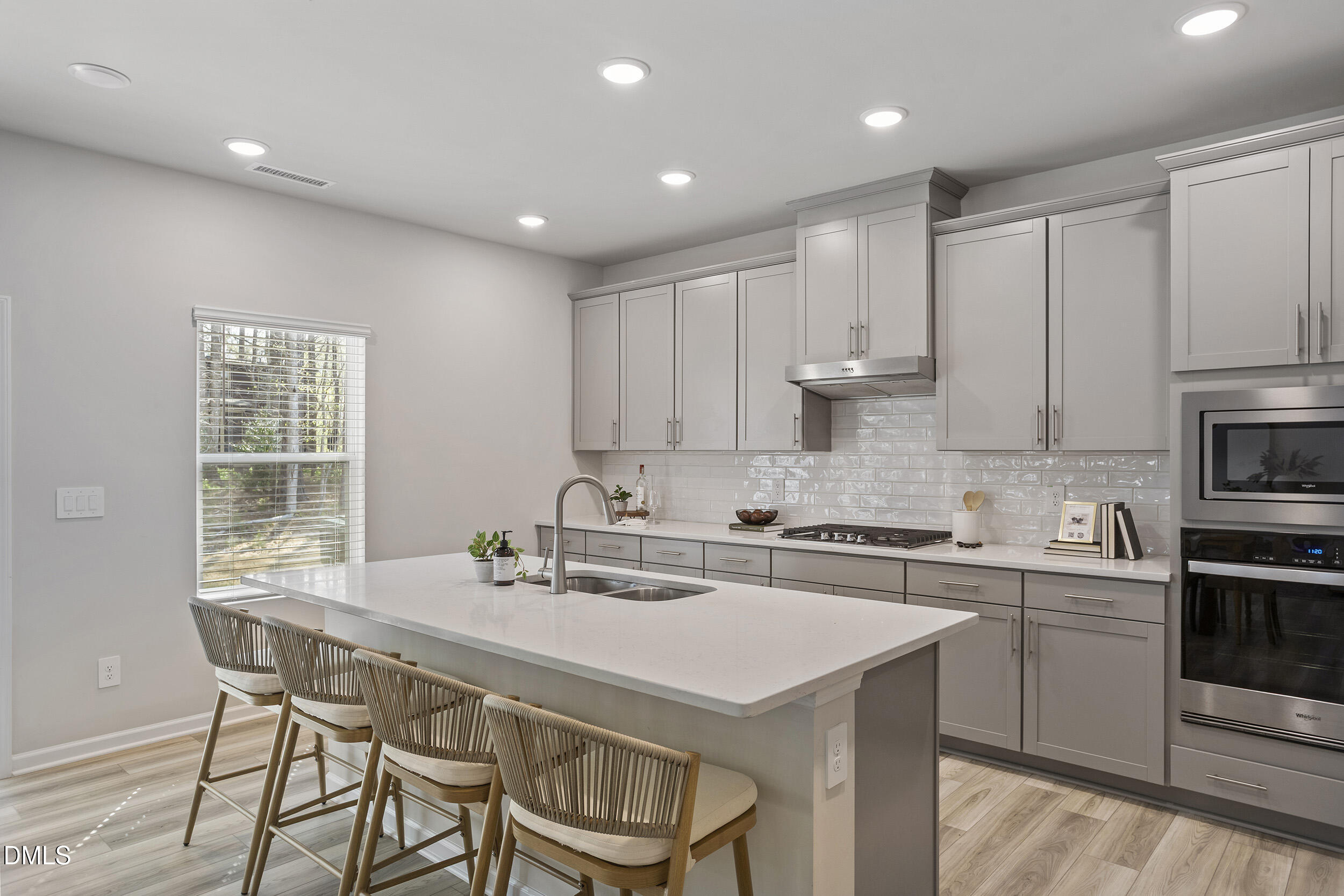 1105 Umstead Grv Way Durham, NC 27712 - Photo 18 of 38 a kitchen with a dining table chairs sink and cabinets