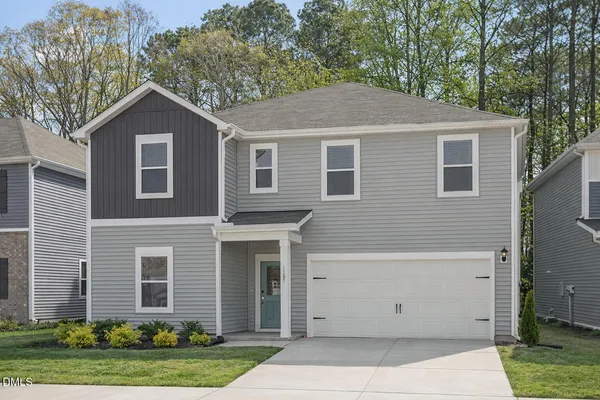 a front view of a house with a yard and garage