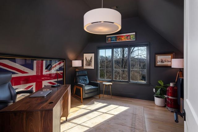 a view of a white house next to a yard with big trees