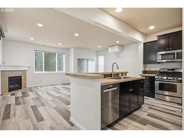 a kitchen with stainless steel appliances granite countertop a stove a sink and a refrigerator