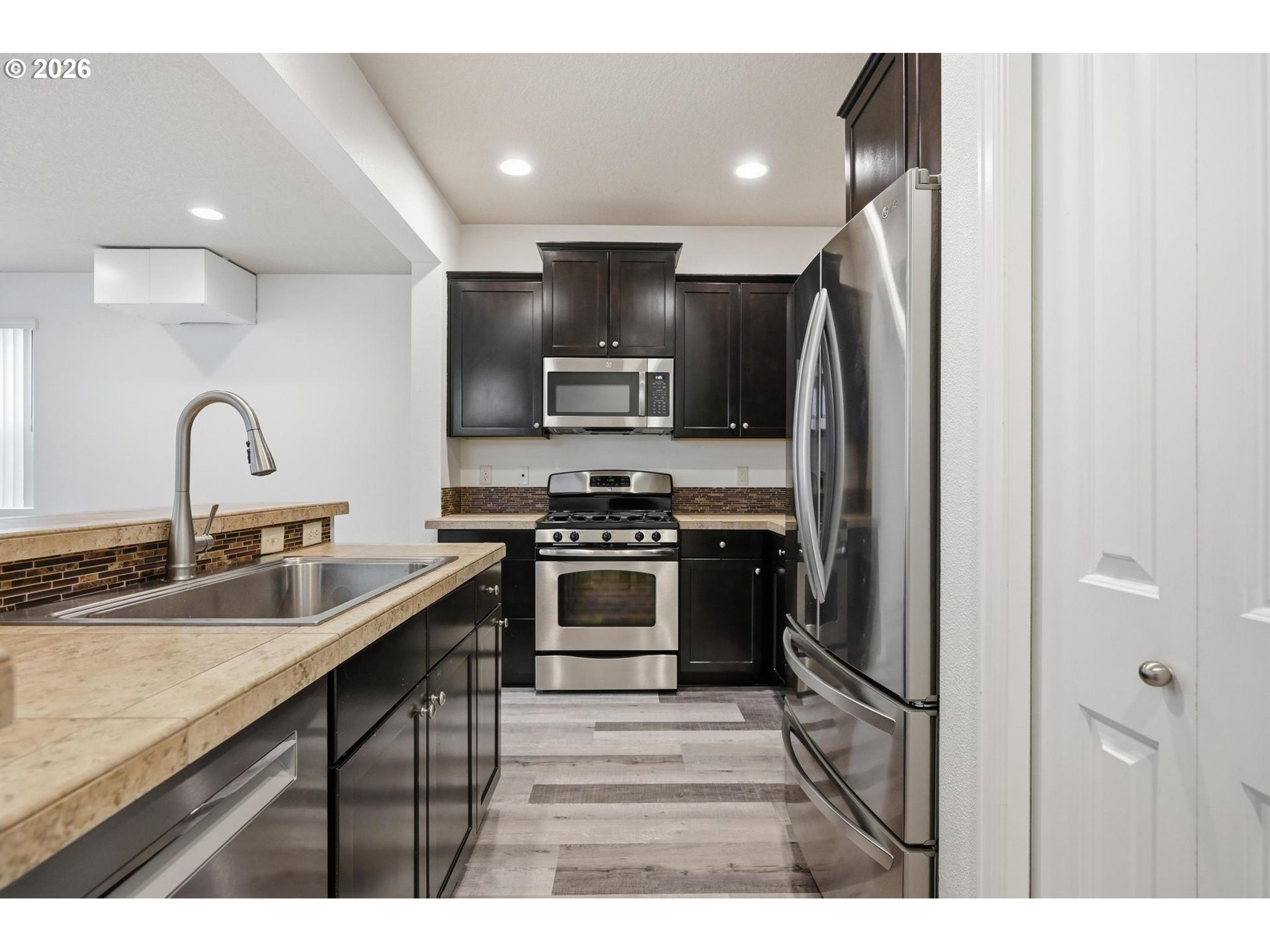 20881 Southwest Edgemont Street Beaverton, OR 97003 - Photo 4 of 39 a kitchen with stainless steel appliances kitchen island a refrigerator and a sink
