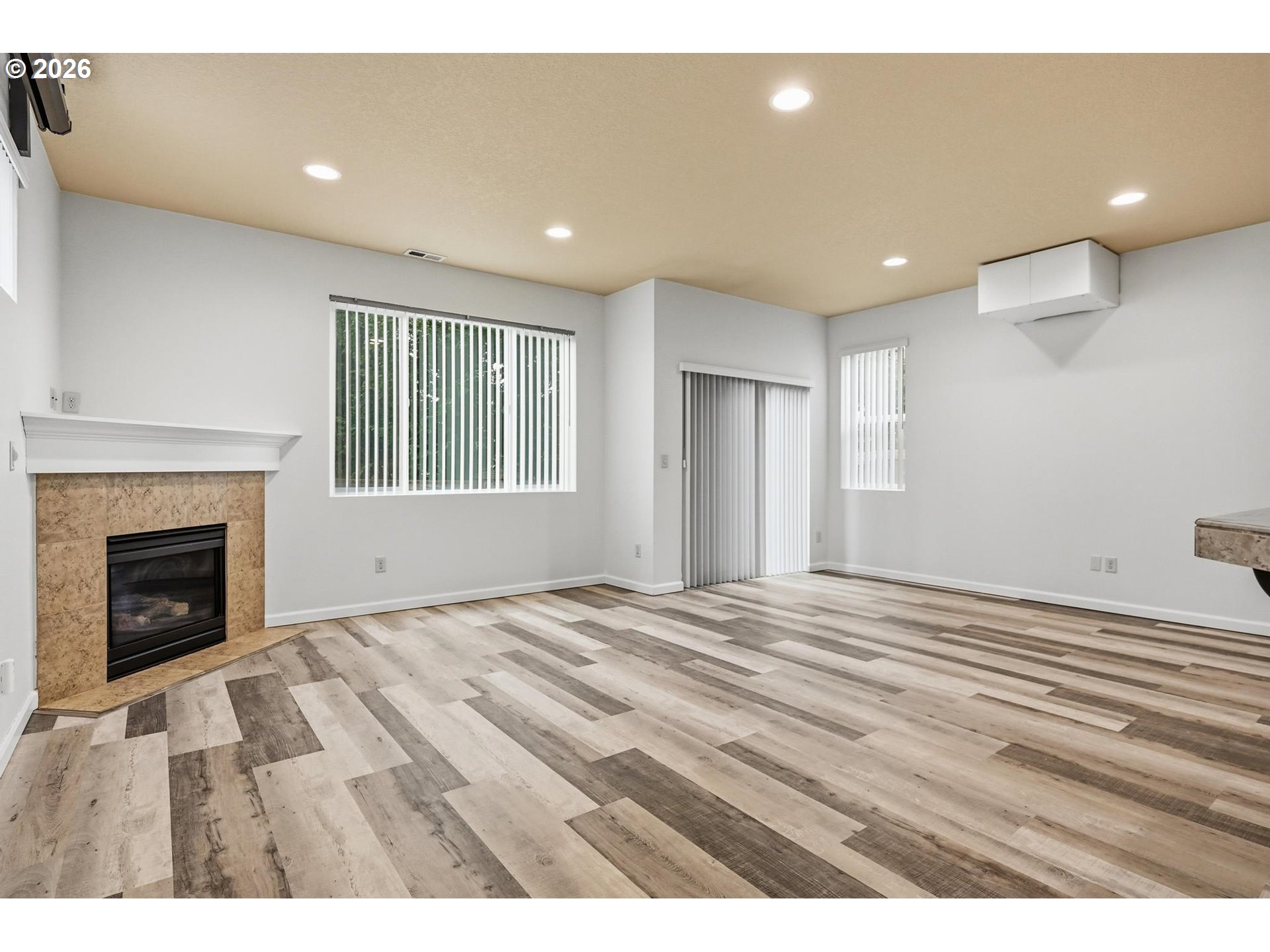 20881 Southwest Edgemont Street Beaverton, OR 97003 - Photo 6 of 39 a view of an empty room with wooden floor fireplace and a window