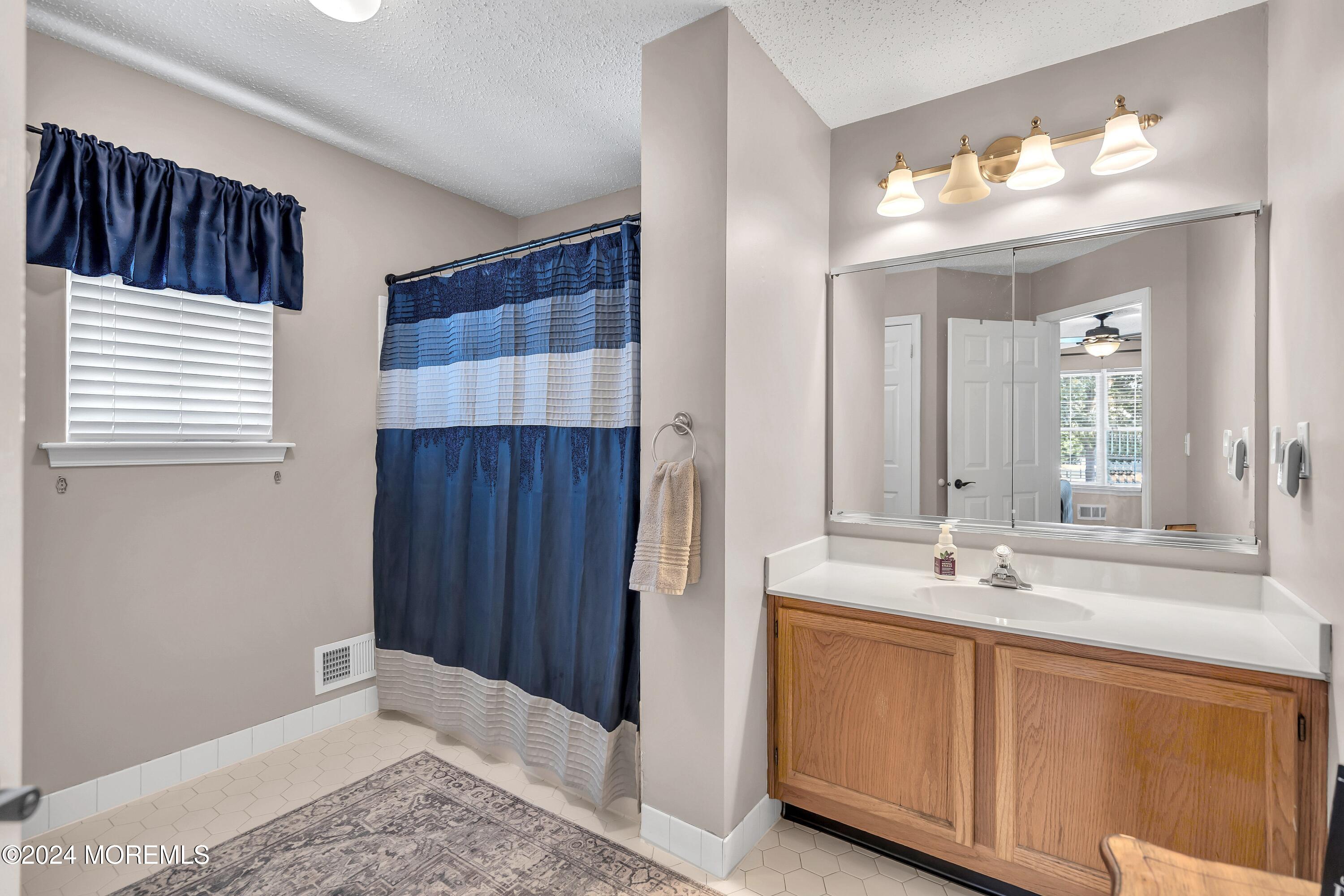 161 Old Orchard Road Toms River, NJ 08755 - Photo 19 of 32 a bathroom with a sink a mirror and a shower