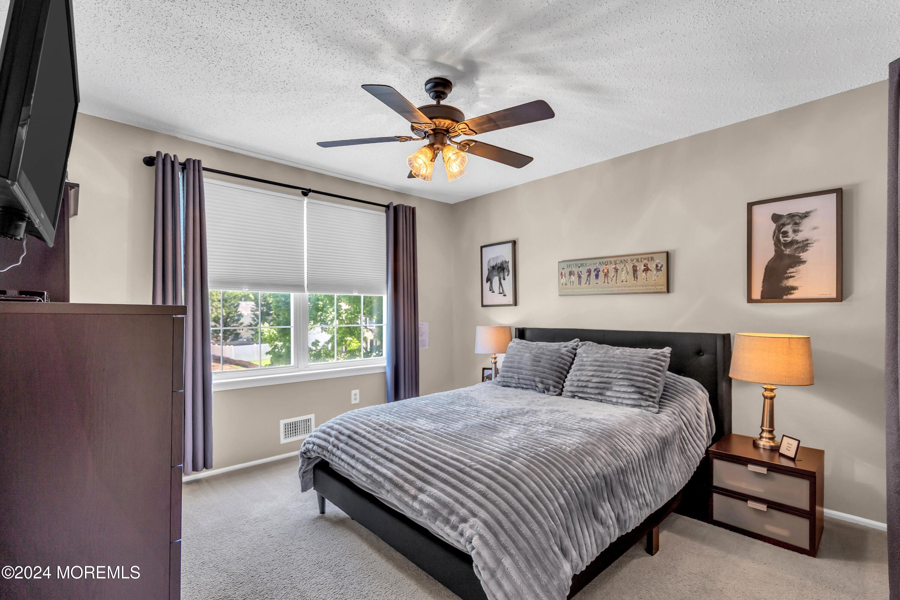 161 Old Orchard Road Toms River, NJ 08755 - Photo 21 of 32 a bedroom with a bed and a chandelier