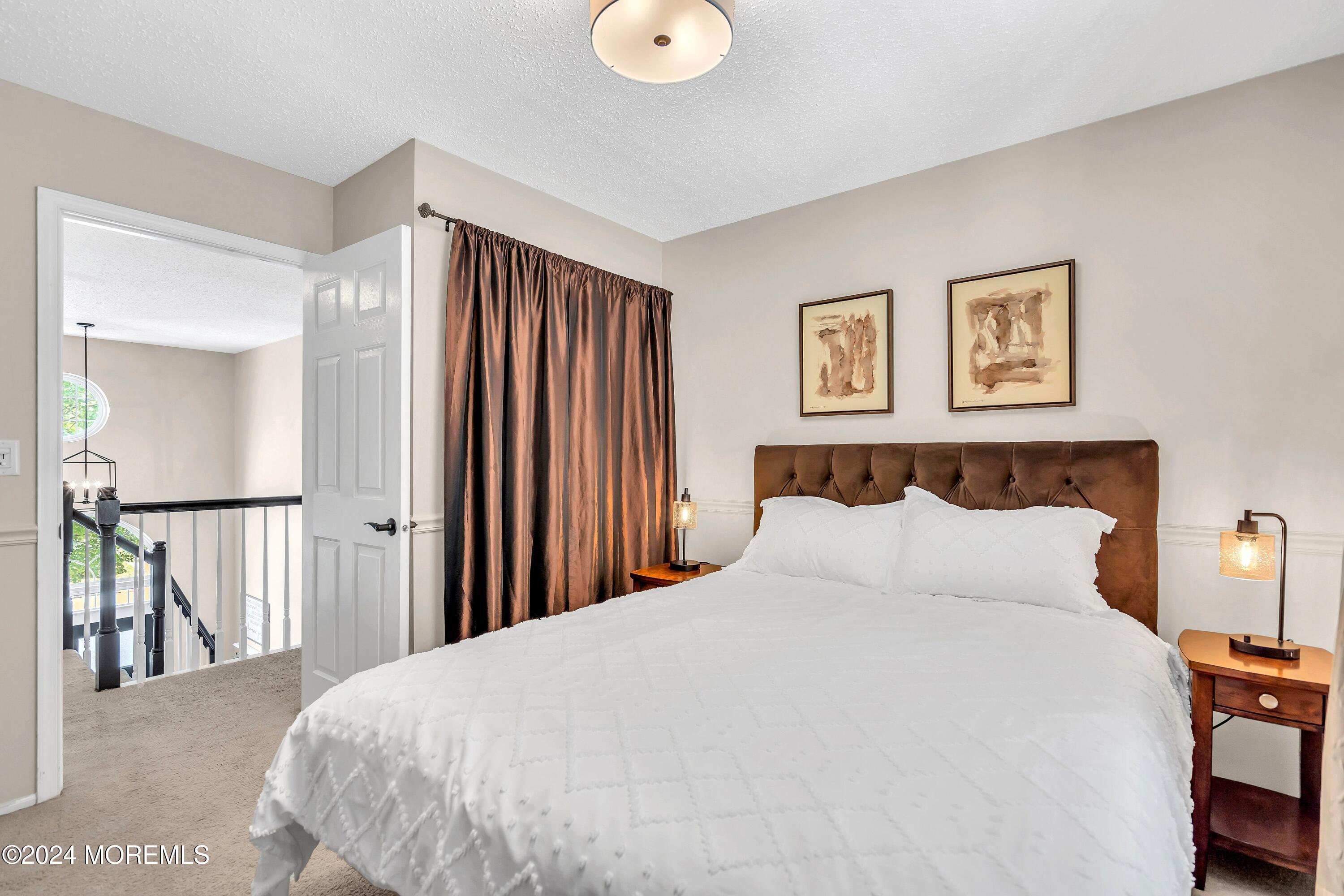 161 Old Orchard Road Toms River, NJ 08755 - Photo 24 of 32 a bedroom with a large bed and a chandelier