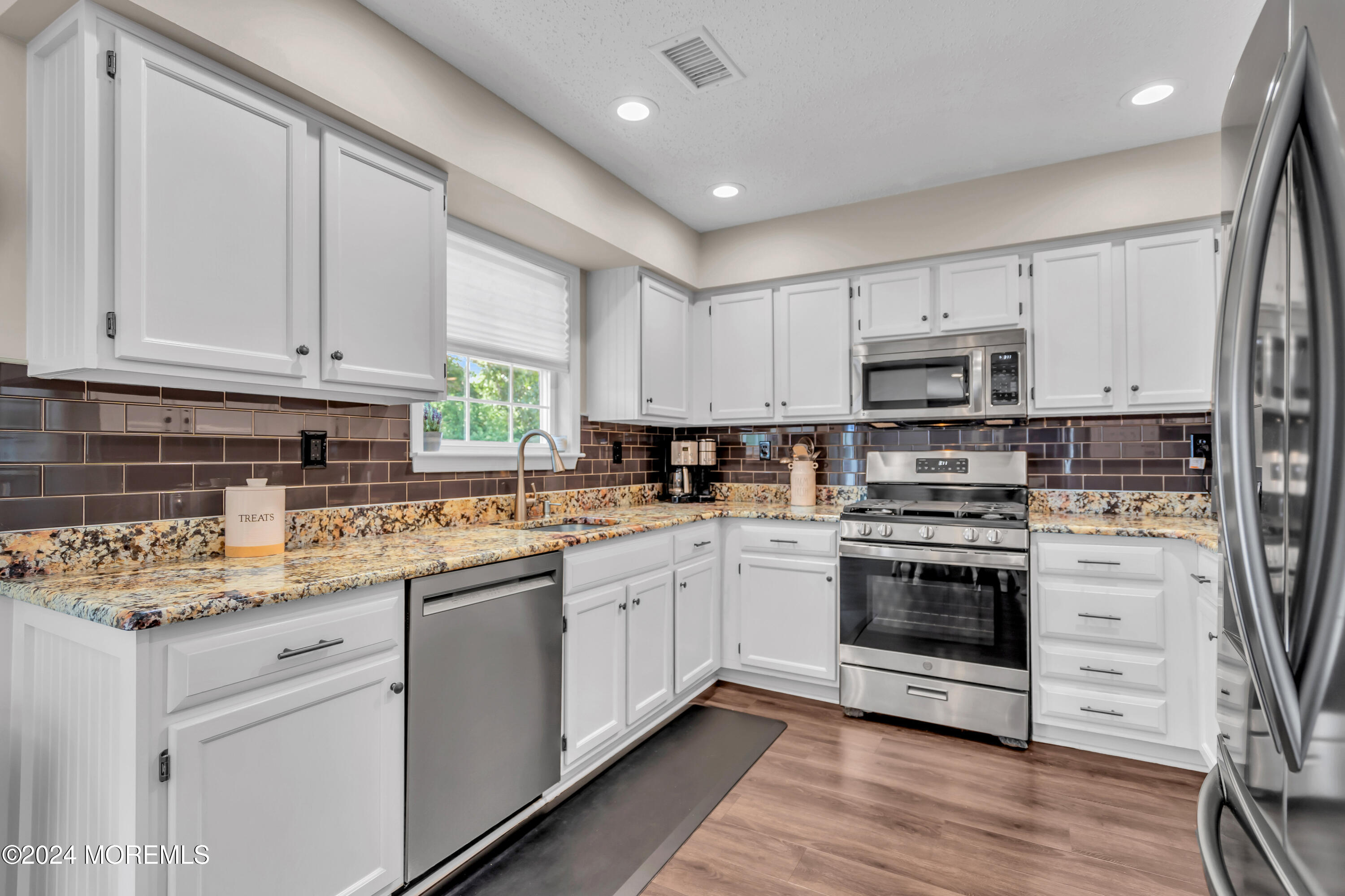 161 Old Orchard Road Toms River, NJ 08755 - Photo 8 of 32 a kitchen with kitchen island granite countertop white cabinets and white appliances
