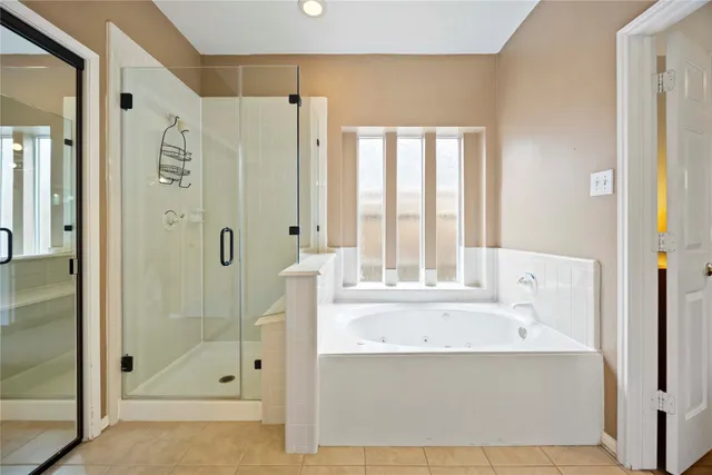 a bathroom with a tub shower sink and mirror