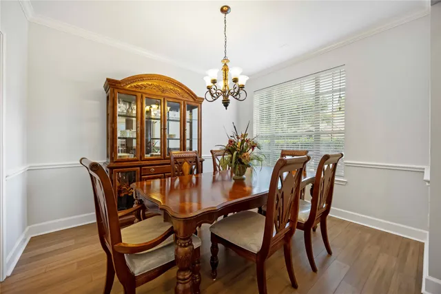 a dining room with furniture a chandelier and wooden floor