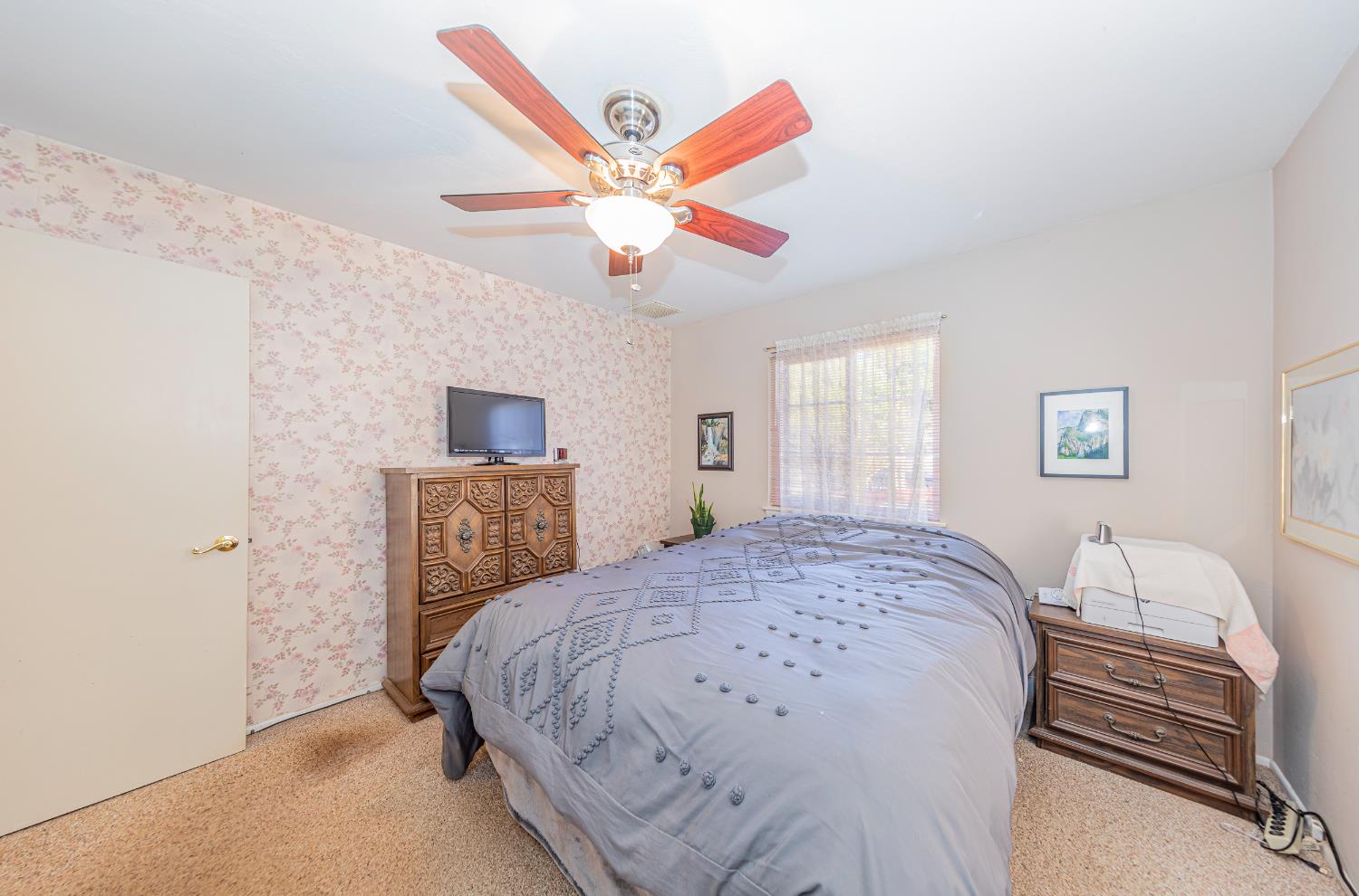 42585 Buckeye Road Oakhurst, CA 93644 - Photo 21 of 55 a bedroom with a bed and a chandelier