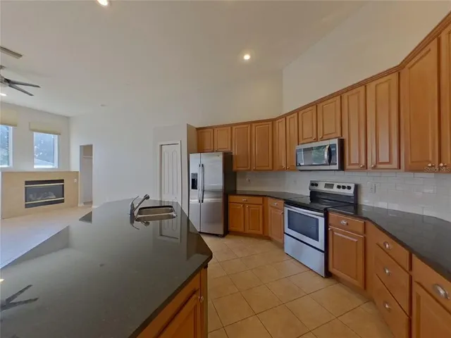 a kitchen with stainless steel appliances granite countertop white cabinets a stove top oven a sink and dishwasher