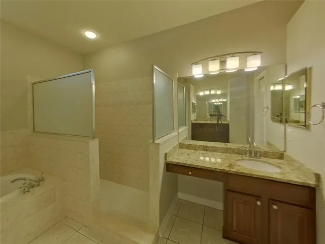 a bathroom with a granite countertop sink a mirror and a shower