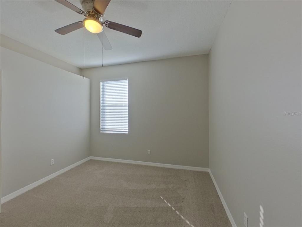 Undisclosed Address Valrico, FL 33596 - Photo 9 of 16 an empty room with a window and a fan
