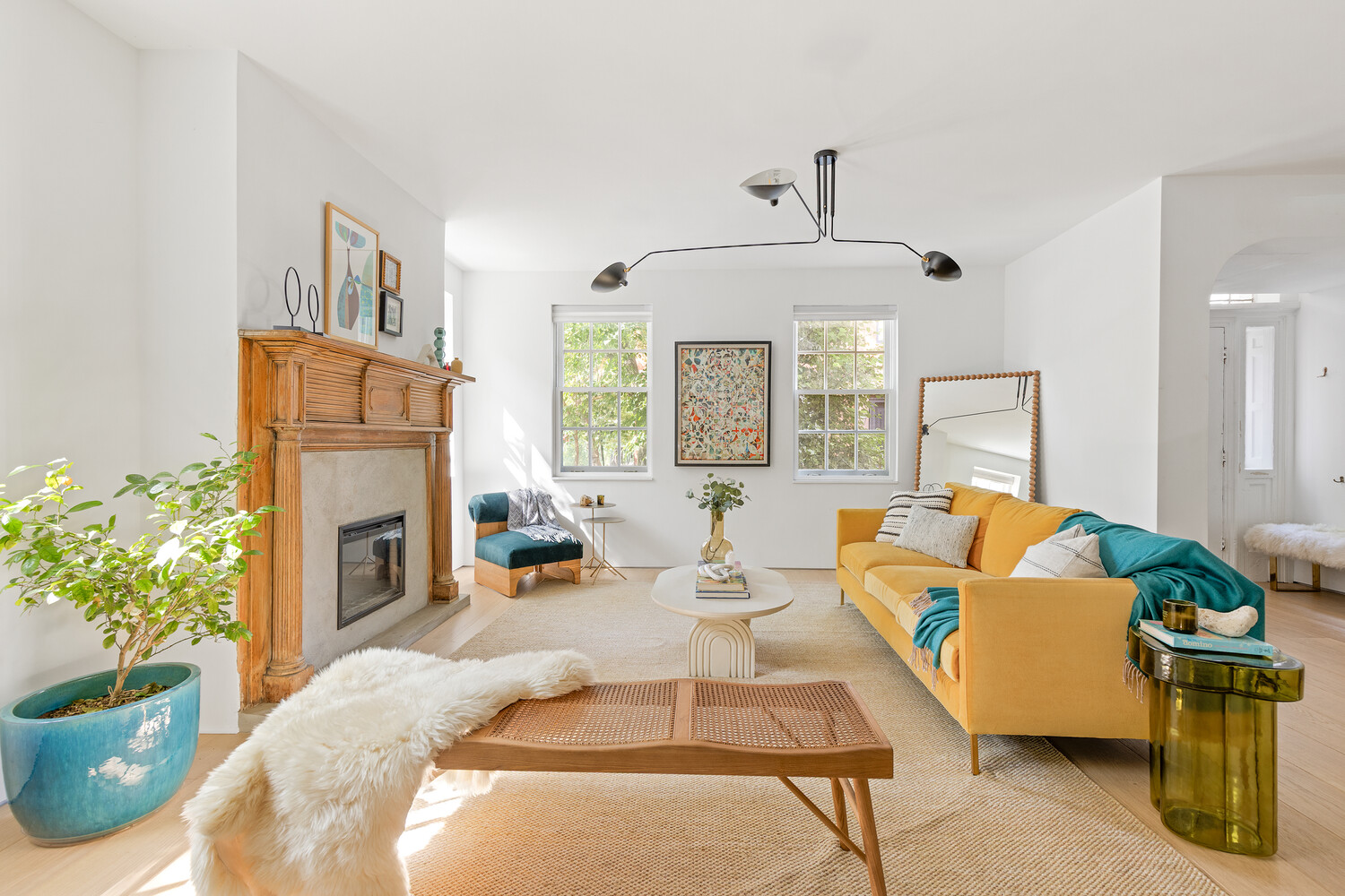 a living room with furniture fireplace and potted plants