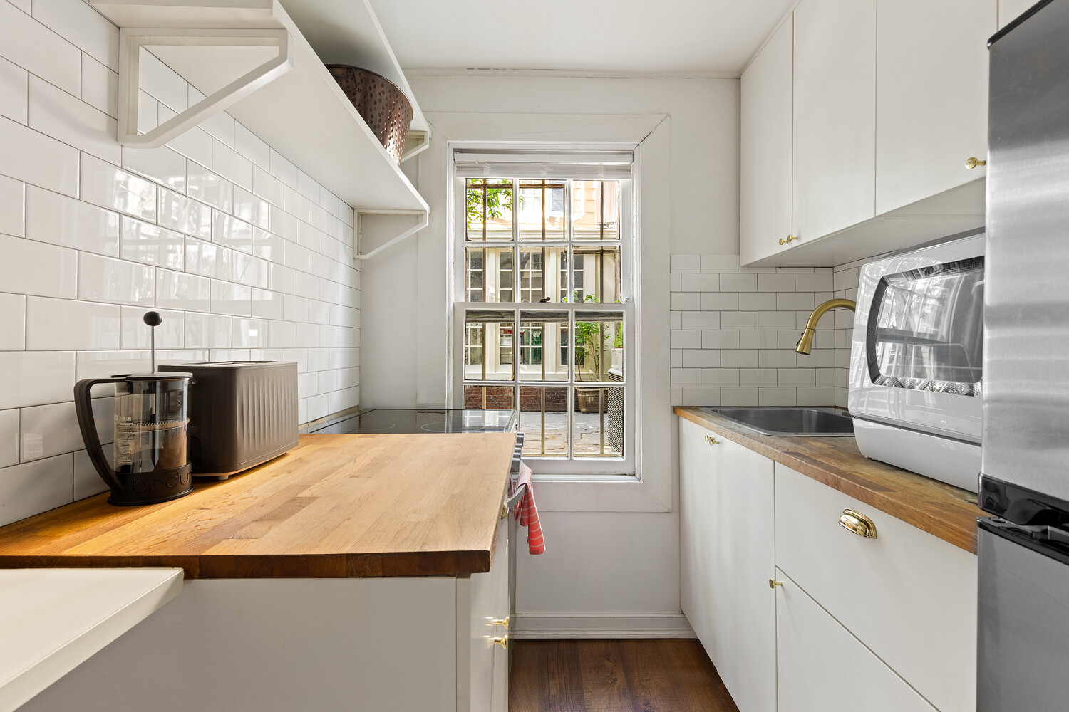 24 Middagh Street Brooklyn, NY 11201 - Photo 27 of 34 a kitchen with a sink a stove and wooden cabinets