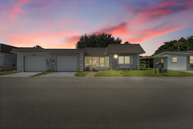 a front view of a house with a garden and yard