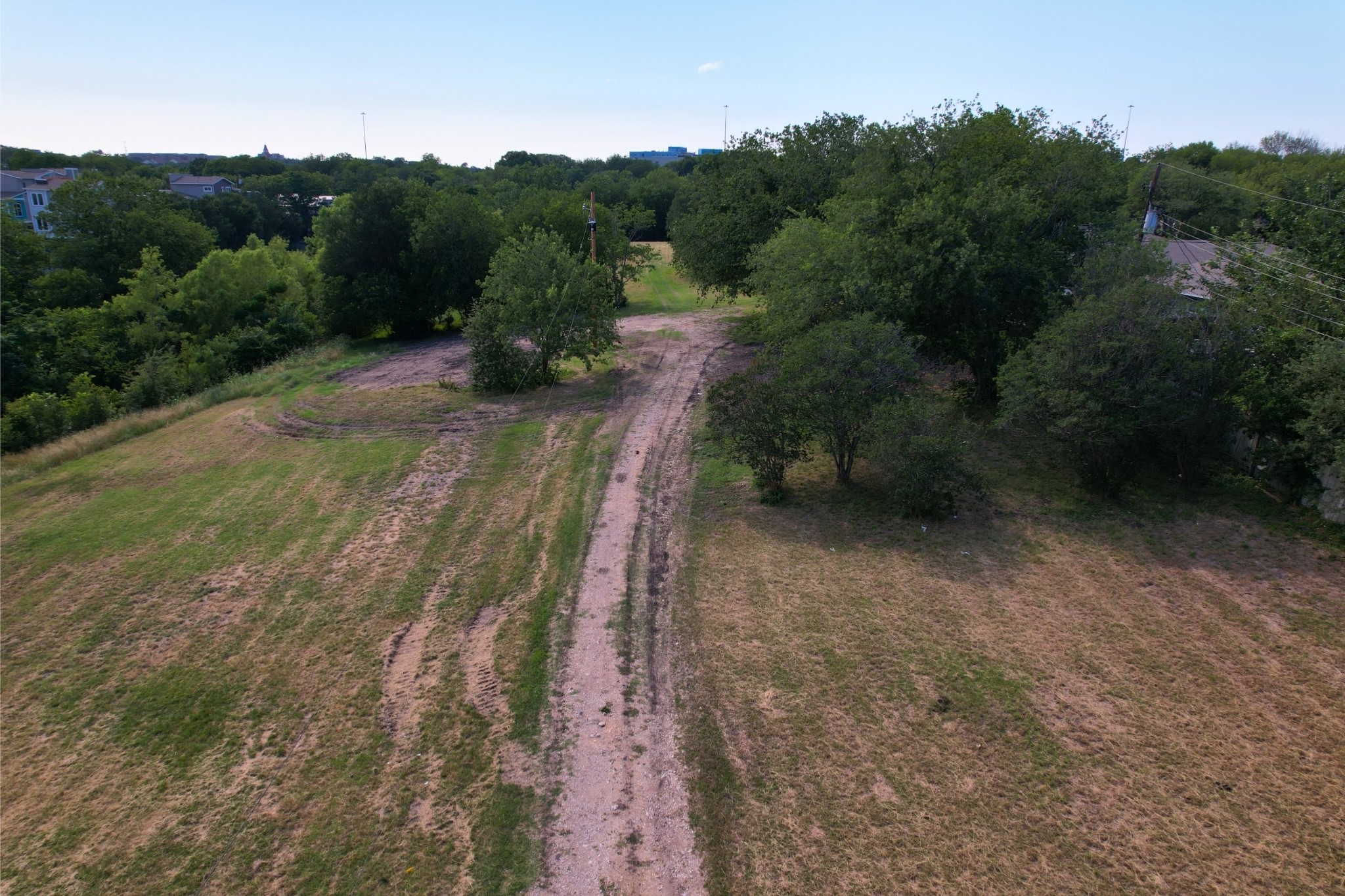 2610-2606 Metcalfe Road Austin, TX 78741 - Photo 11 of 20 A tranquil, undeveloped lot featuring a winding dirt path amidst abundant greenery, offering a prime building opportunity.