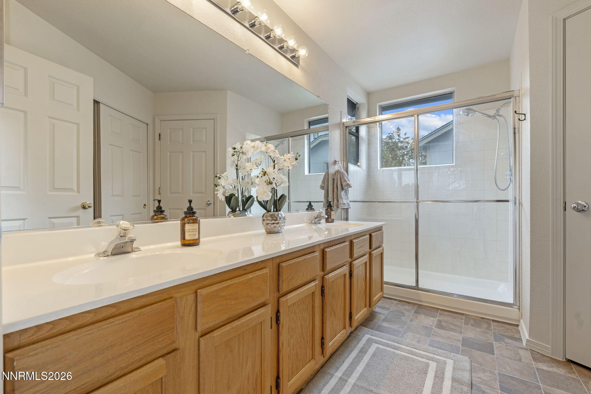 4628 Windcrest Drive Reno, NV 89523 - Photo 23 of 38 a bathroom with double vanity sink and a mirror