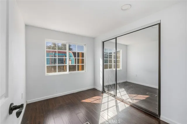 a view of an empty room with wooden floor