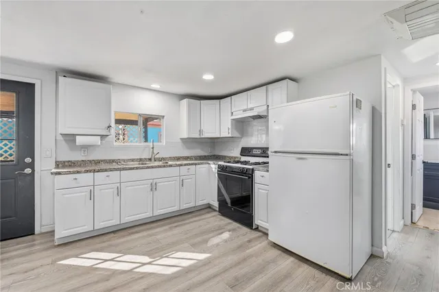 a kitchen with a refrigerator stove and sink