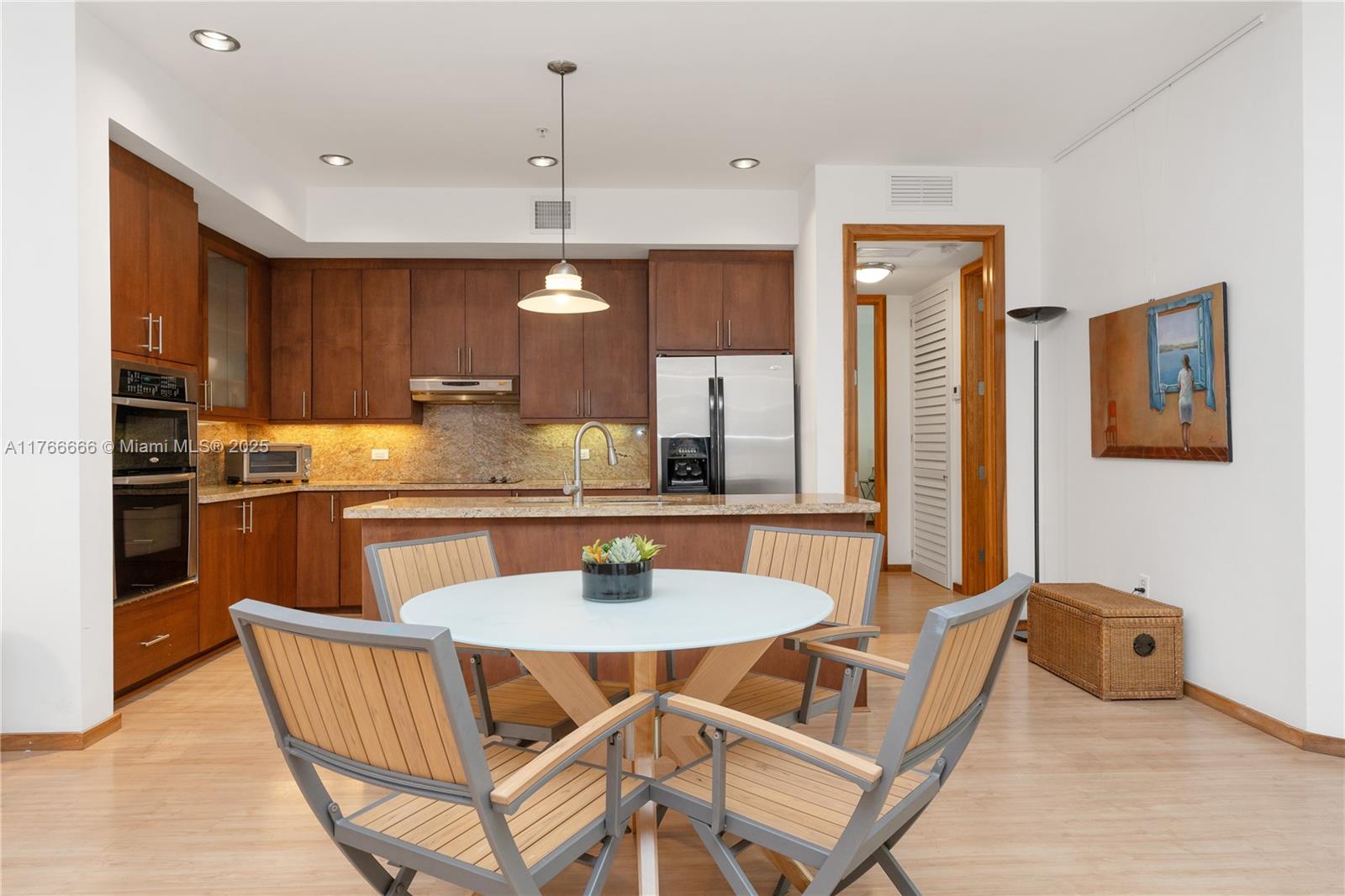 3333 Rice Street, Unit 202 Miami, FL 33133 - Photo 12 of 36 a kitchen with a dining table chairs and refrigerator