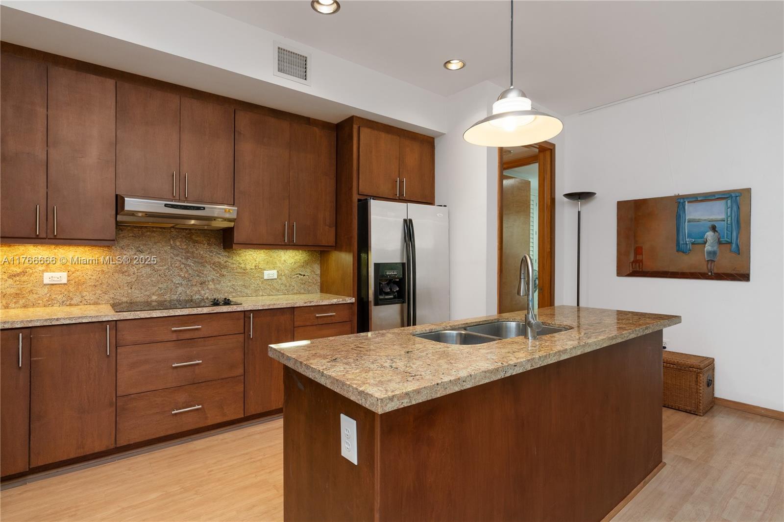 3333 Rice Street, Unit 202 Miami, FL 33133 - Photo 14 of 36 a kitchen with a stove a refrigerator a sink dishwasher with wooden cabinets and floor