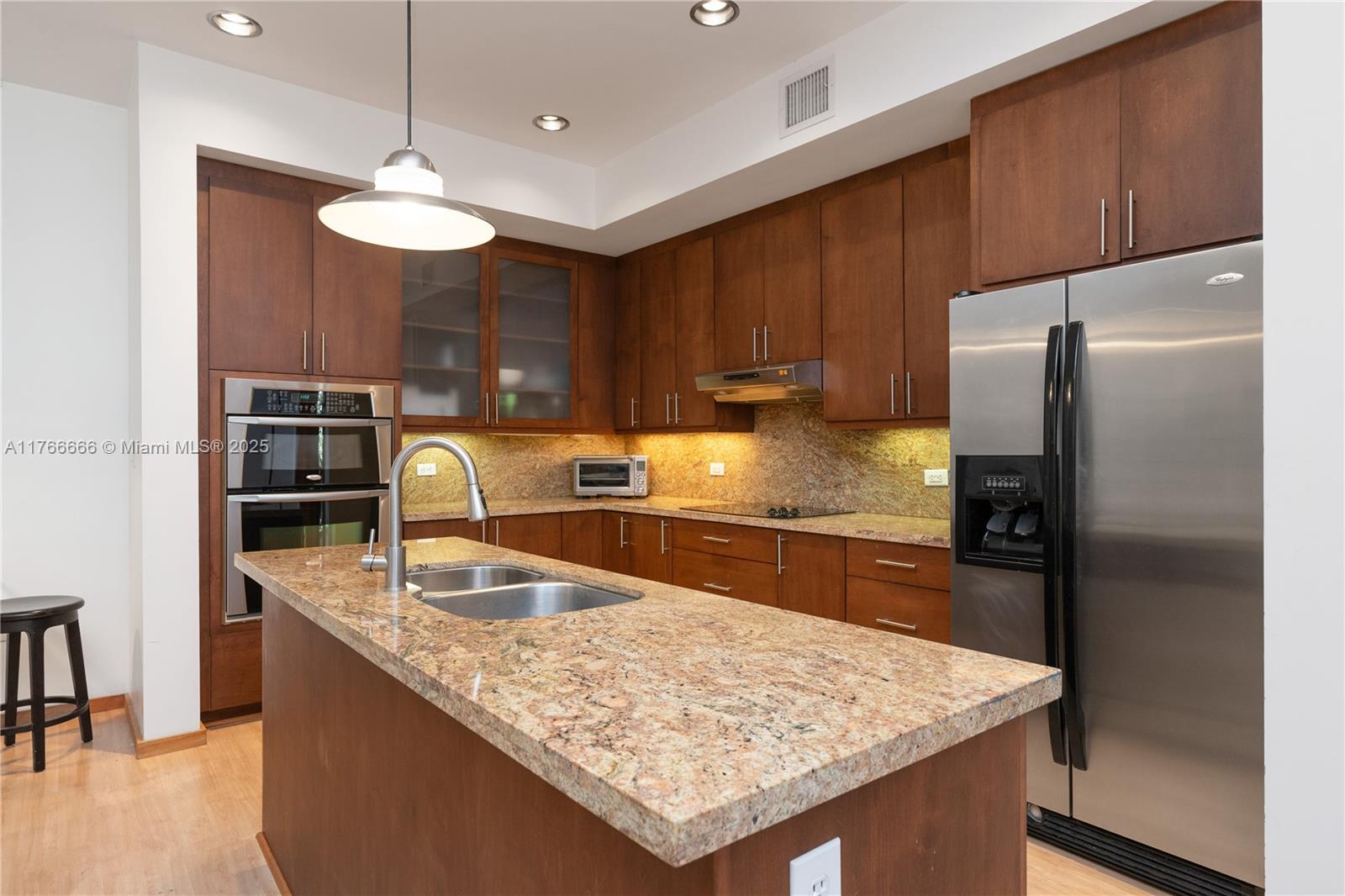 3333 Rice Street, Unit 202 Miami, FL 33133 - Photo 15 of 36 a kitchen with stainless steel appliances granite countertop a sink refrigerator and microwave
