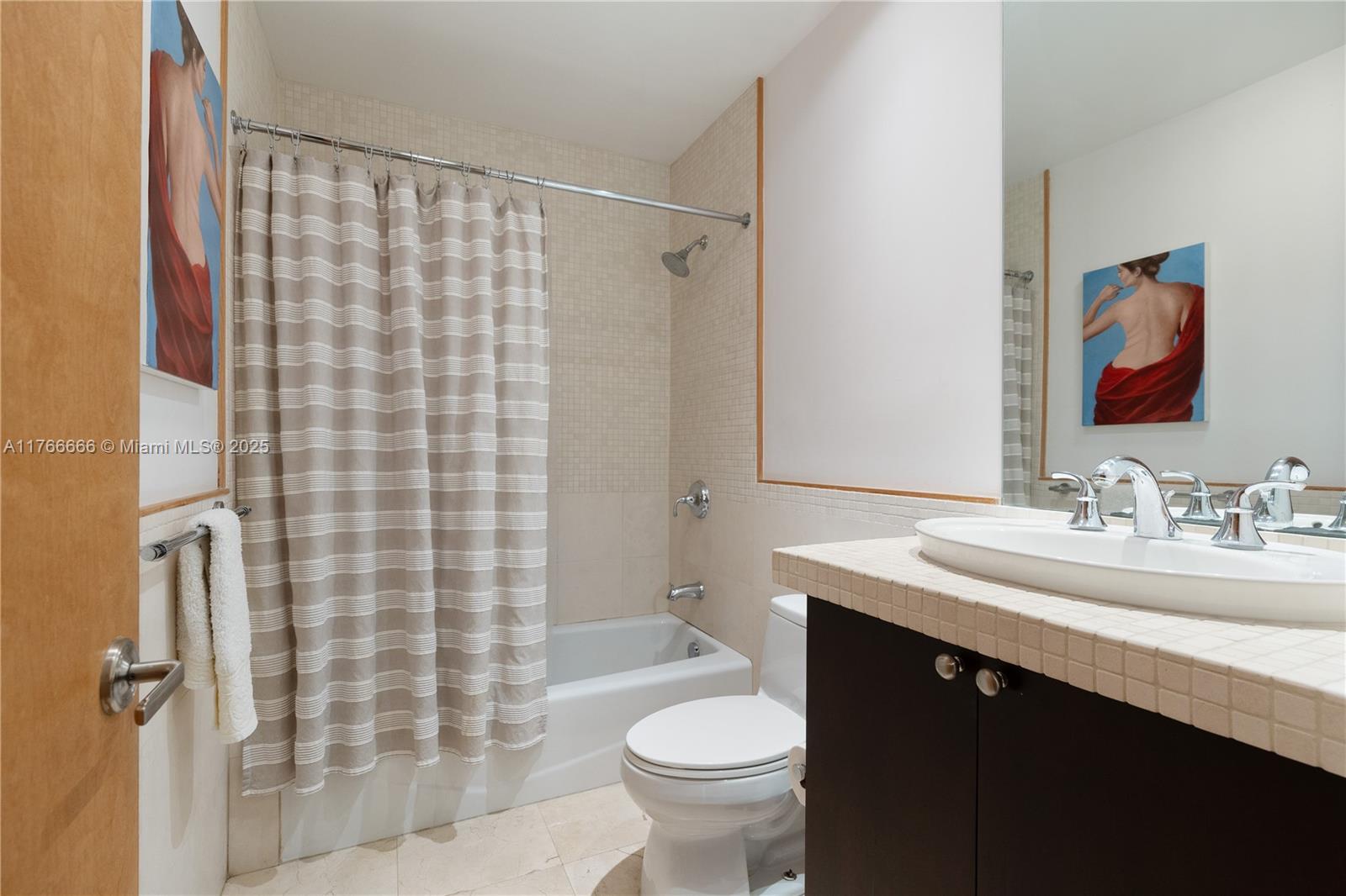 3333 Rice Street, Unit 202 Miami, FL 33133 - Photo 17 of 36 a bathroom with a sink a toilet and shower curtain