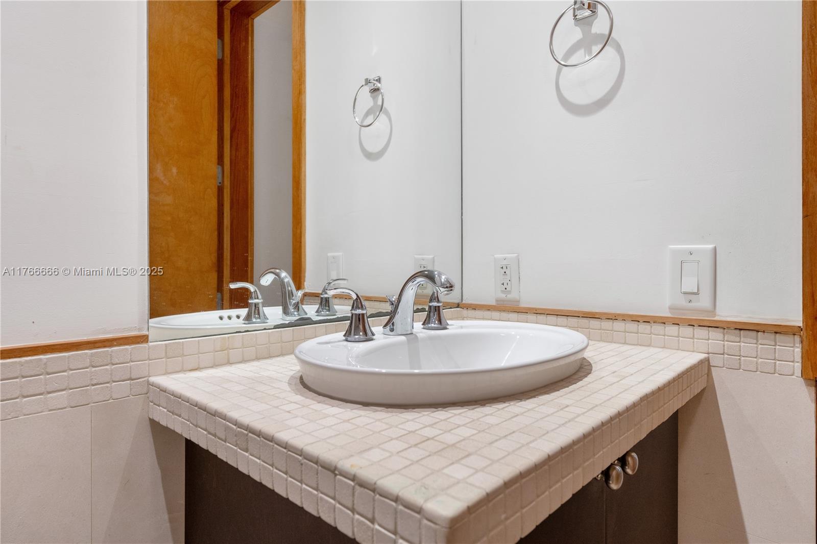 3333 Rice Street, Unit 202 Miami, FL 33133 - Photo 18 of 36 a bathroom with a sink and a mirror