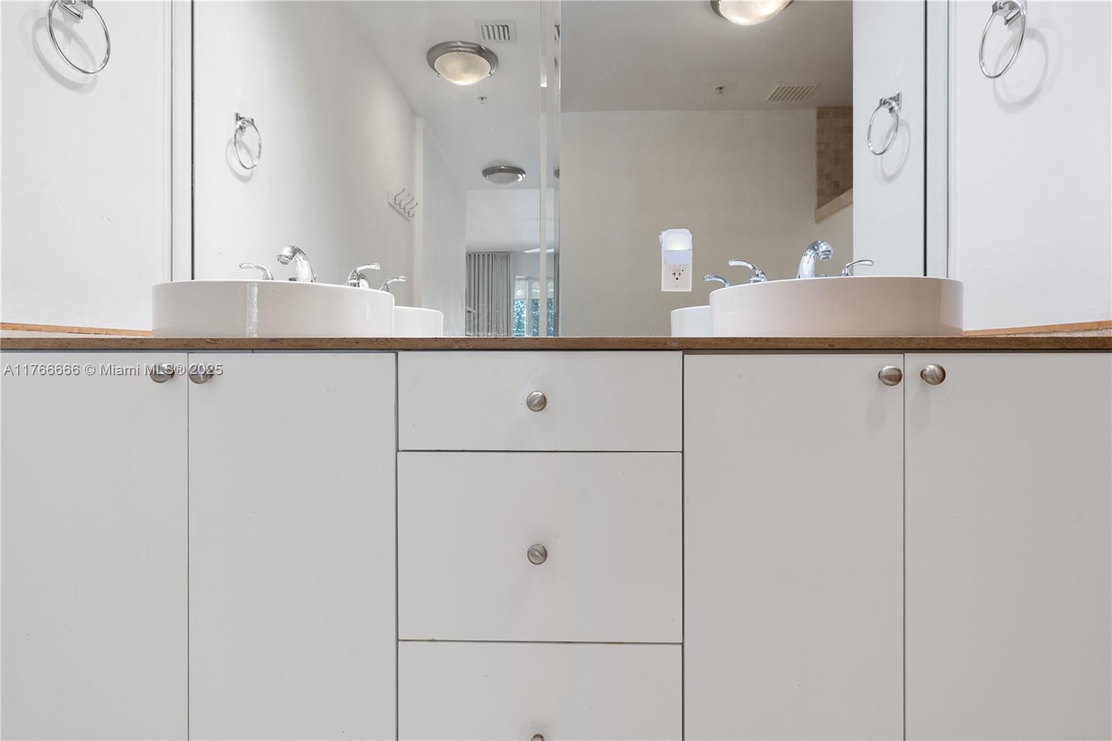 3333 Rice Street, Unit 202 Miami, FL 33133 - Photo 26 of 36 a bathroom with a sink and mirror