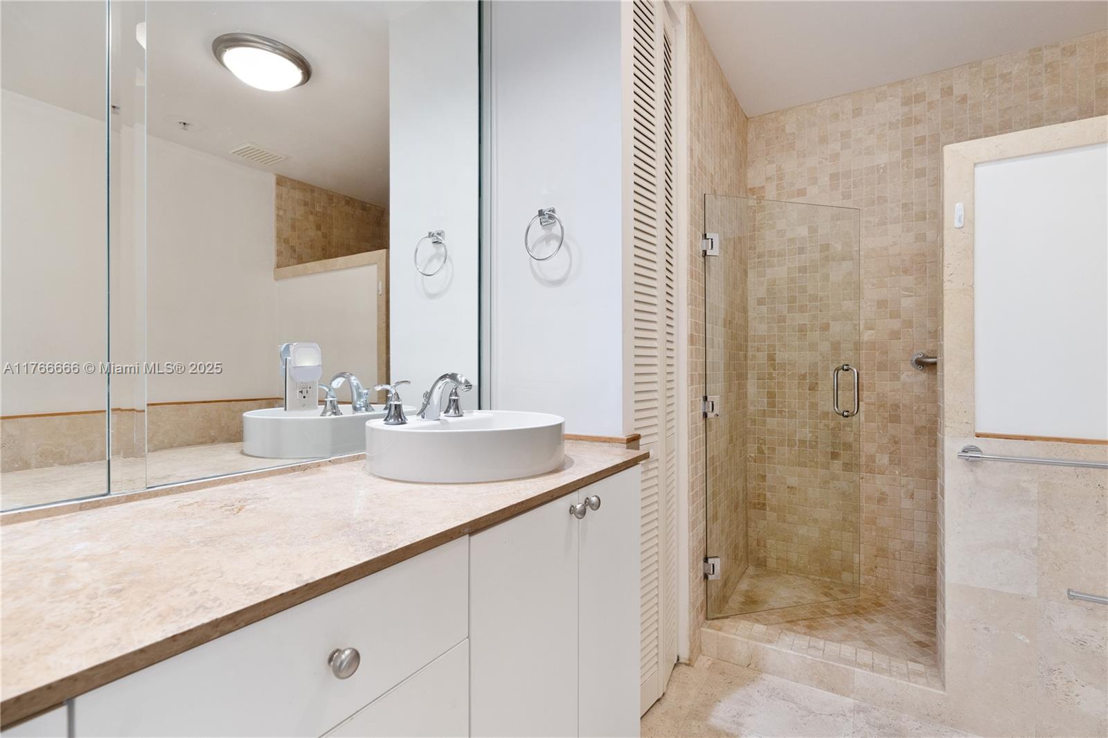 3333 Rice Street, Unit 202 Miami, FL 33133 - Photo 27 of 36 a bathroom with a shower sink and mirror