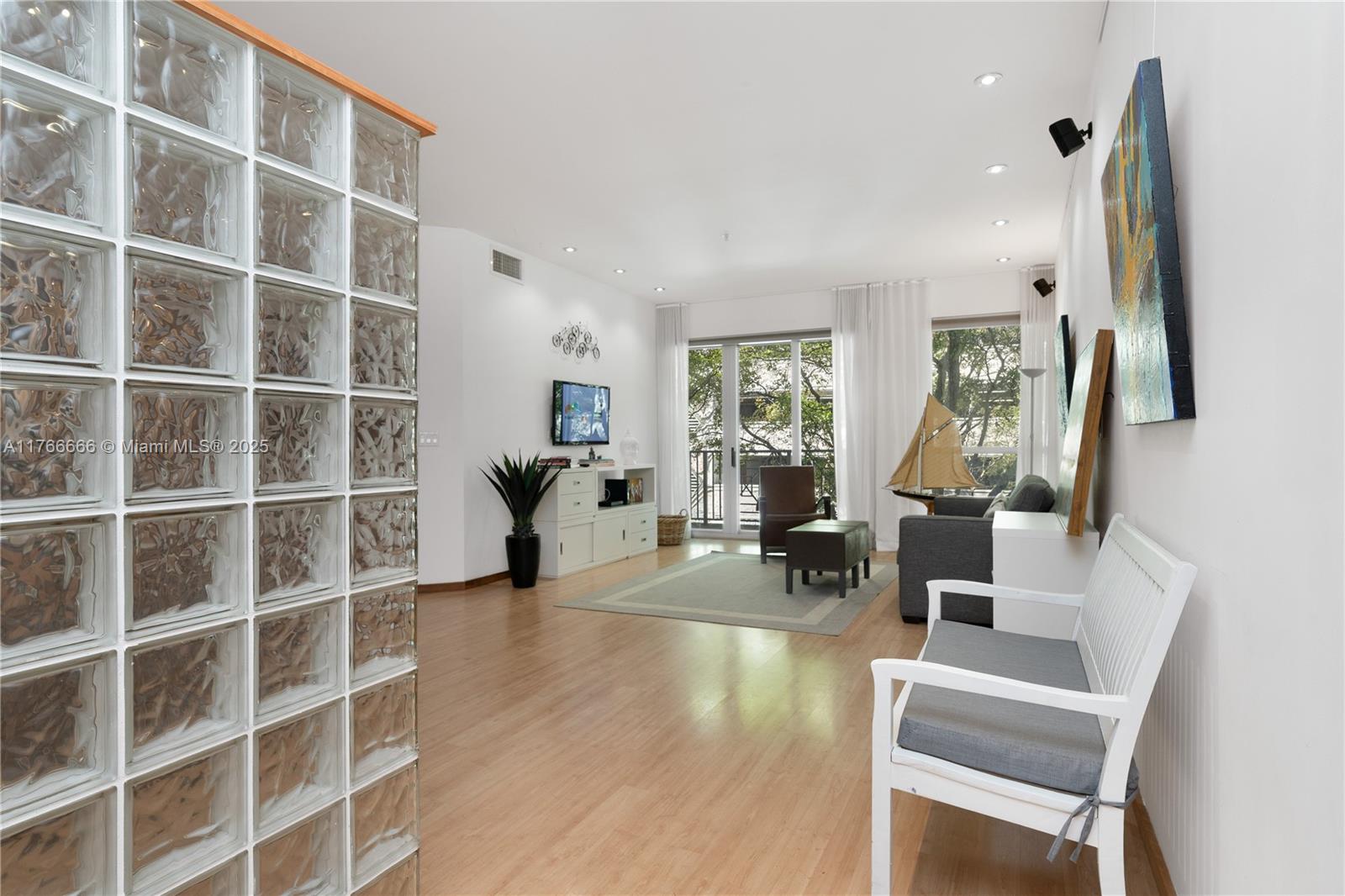 3333 Rice Street, Unit 202 Miami, FL 33133 - Photo 6 of 36 a living room with furniture a lamp and a window