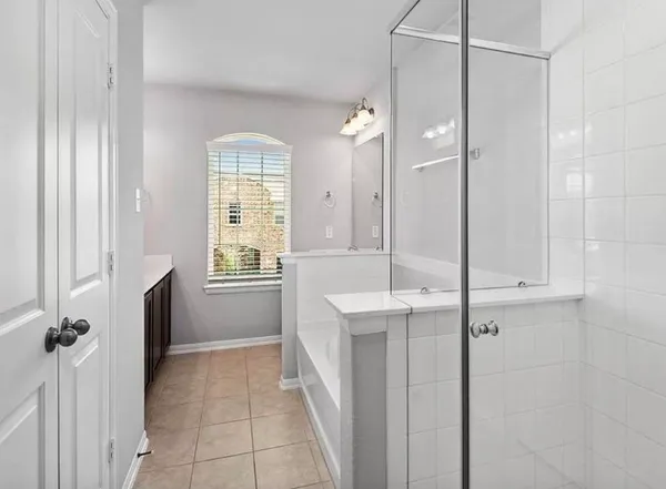 a bathroom with a bathtub a shower a sink and a window