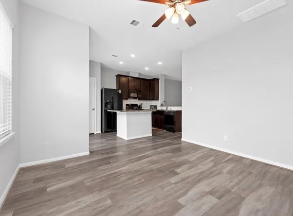 a view of kitchen with microwave stove refrigerator and cabinets