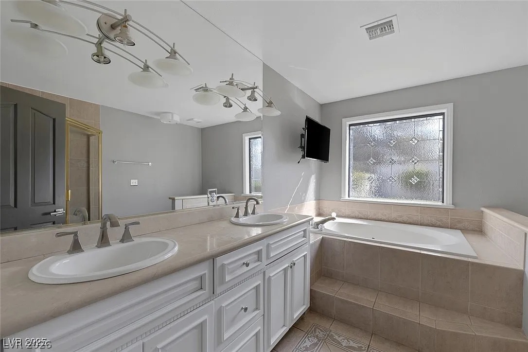 9 Quail Run Road Henderson, NV 89014 - Photo 28 of 57 Dual vanity sinks complement a spacious built-in tub in this well-appointed bathroom.
