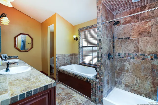 a bathroom with a granite countertop sink a toilet and bathtub