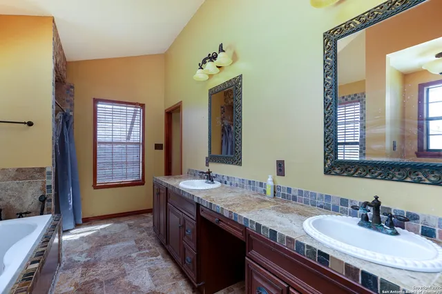 a bathroom with a granite countertop sink a mirror and a shower