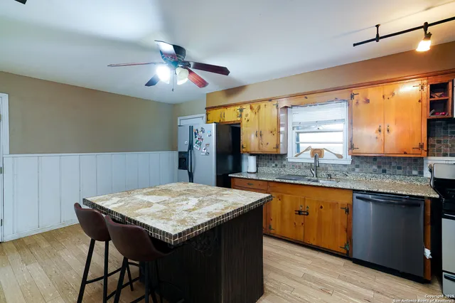 a open kitchen with a table chairs and wooden floor
