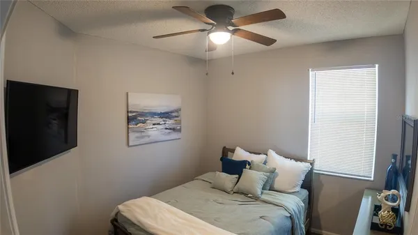 a bedroom with a bed and a flat tv screen on the dresser