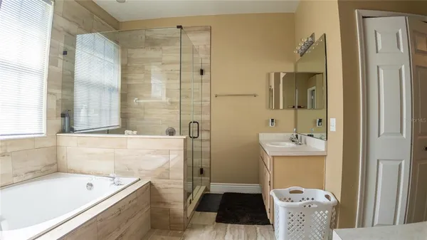 a bathroom with a tub sink and mirror