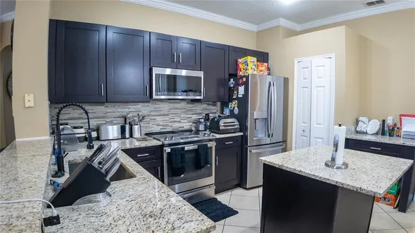 a kitchen with stainless steel appliances granite countertop a sink stove and refrigerator